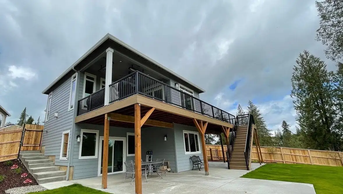 Two-story deck with black railing and stairs over a patio in Portland, OR
