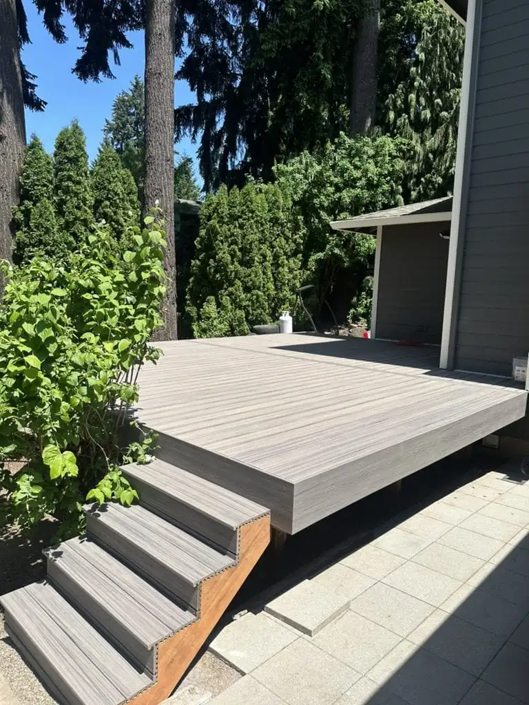 Low gray composite deck with steps onto a paver patio