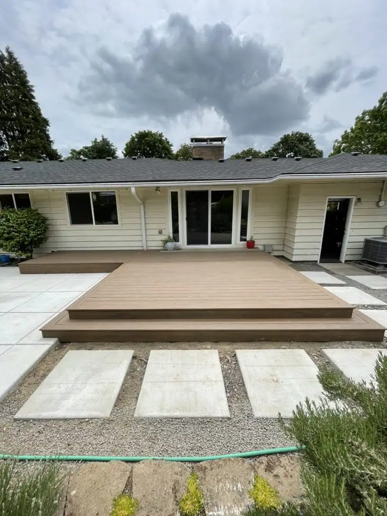 Low composite deck with wide steps and concrete pavers on gravel
