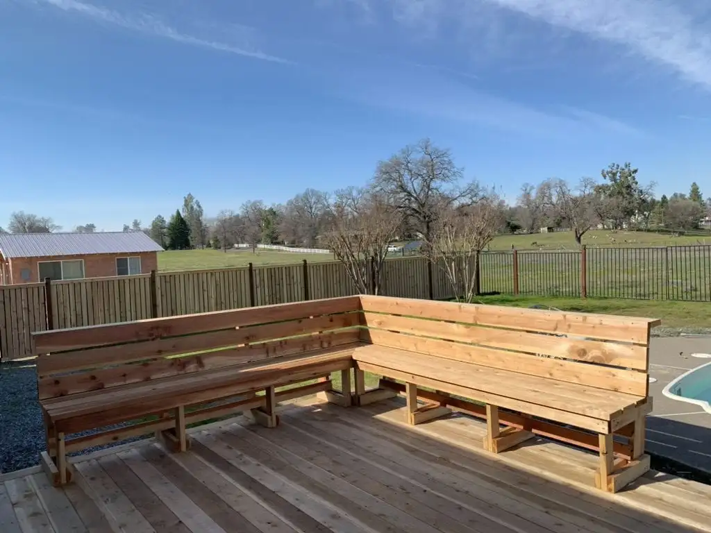 Cedar deck with built-in L-shaped bench seating near a pool