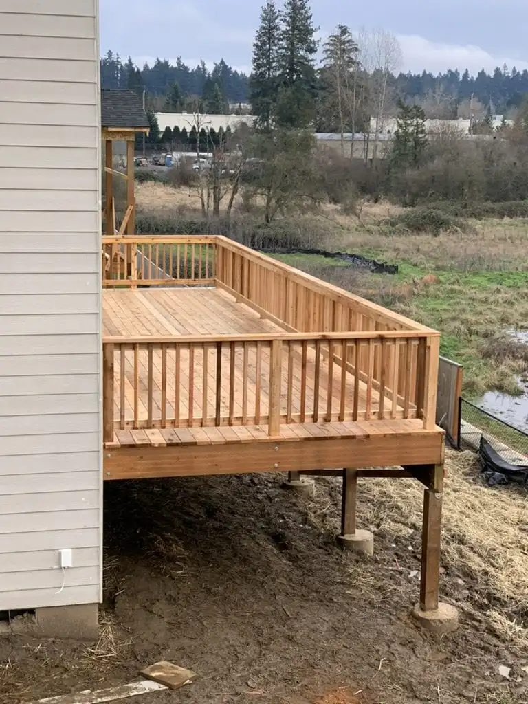 Raised cedar deck with wood railing on a sloped backyard