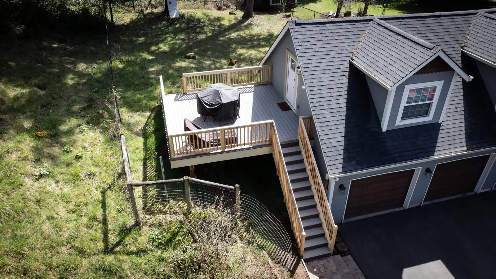 Aerial view of a second-story deck and stairs above a garage