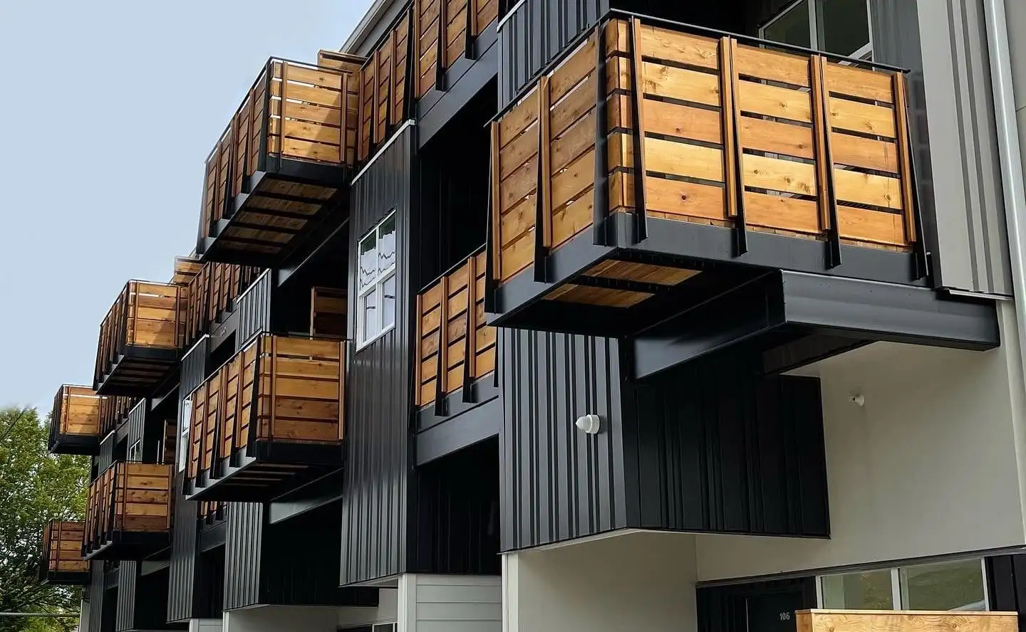 Cedar slat balcony railings with black frames on an apartment building