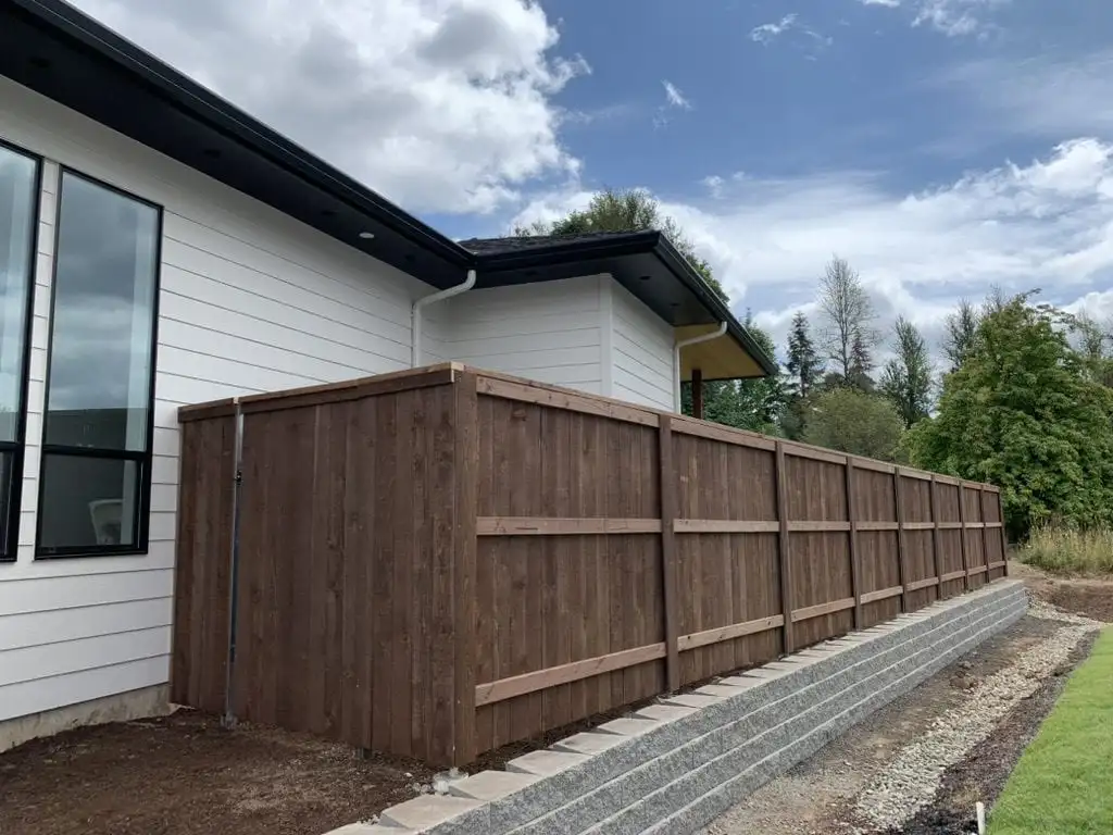 Dark stained wood privacy fence on a block retaining wall in Vancouver, WA