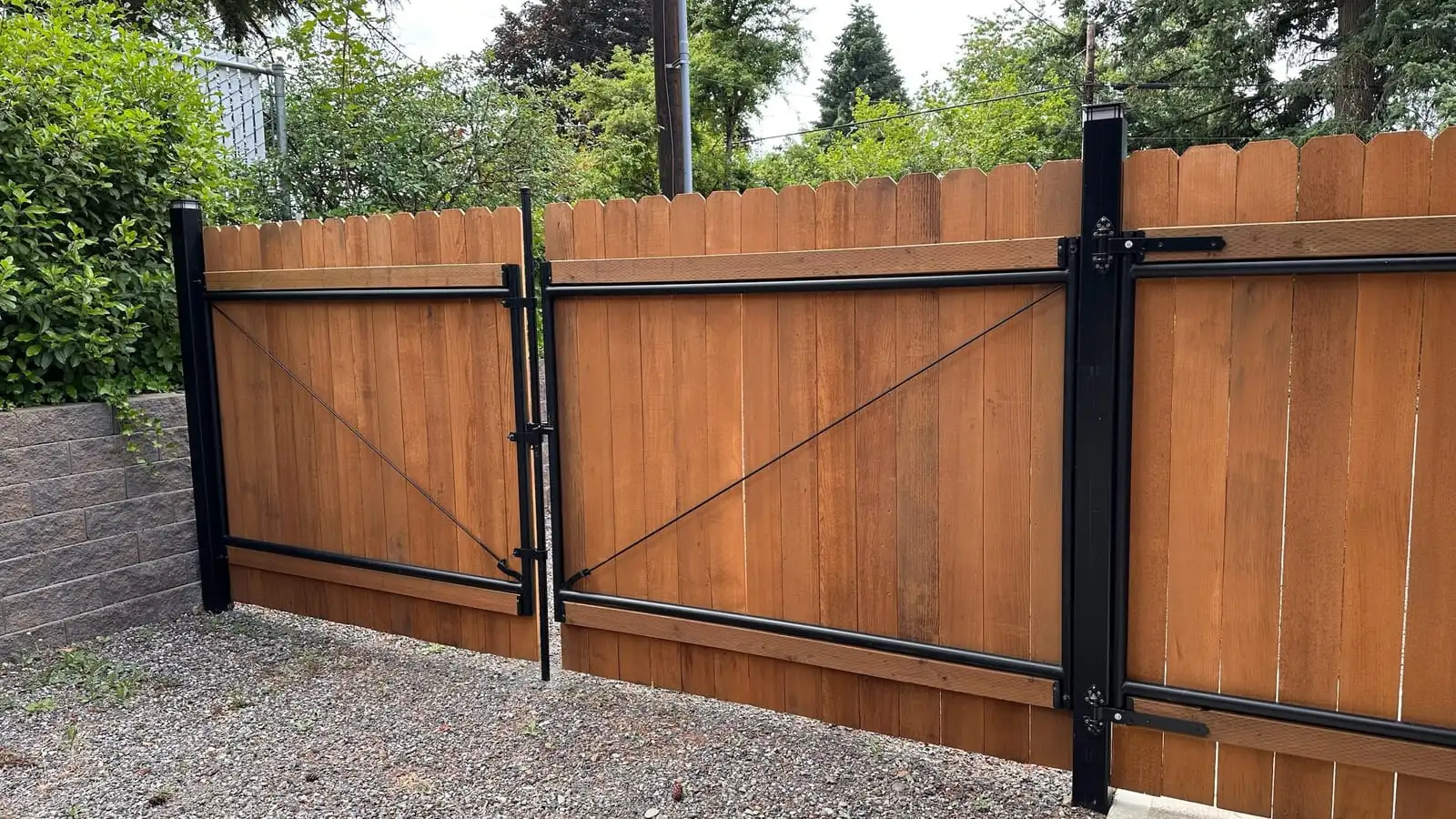 Wood double driveway gate with a black steel frame in Portland, OR