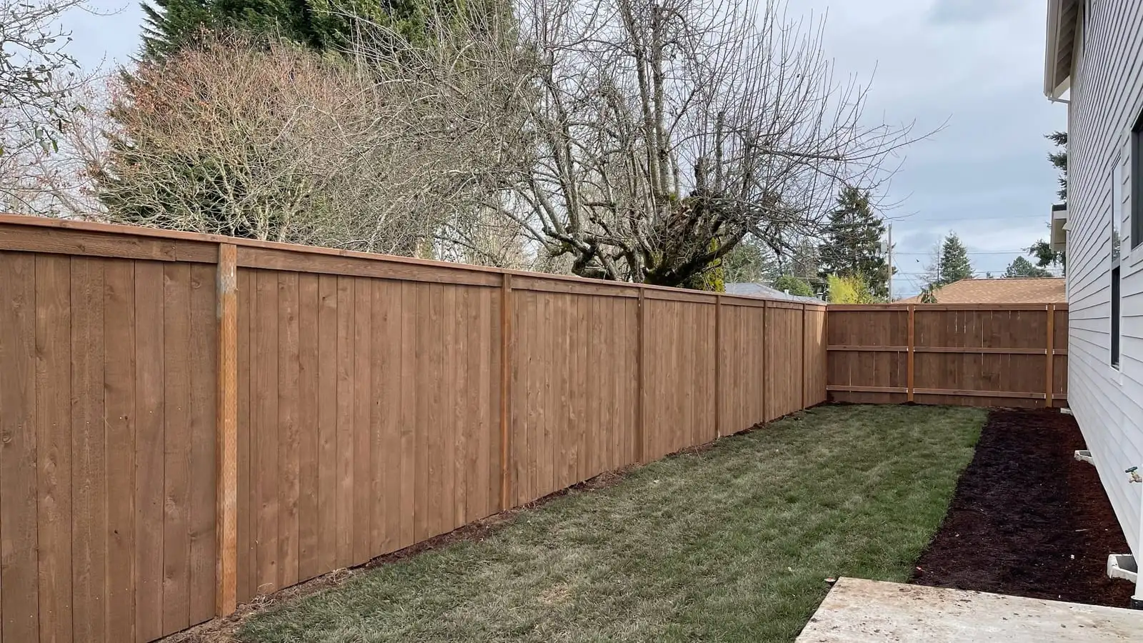 Tall cedar privacy fence along a newly sodded side yard in Portland, OR